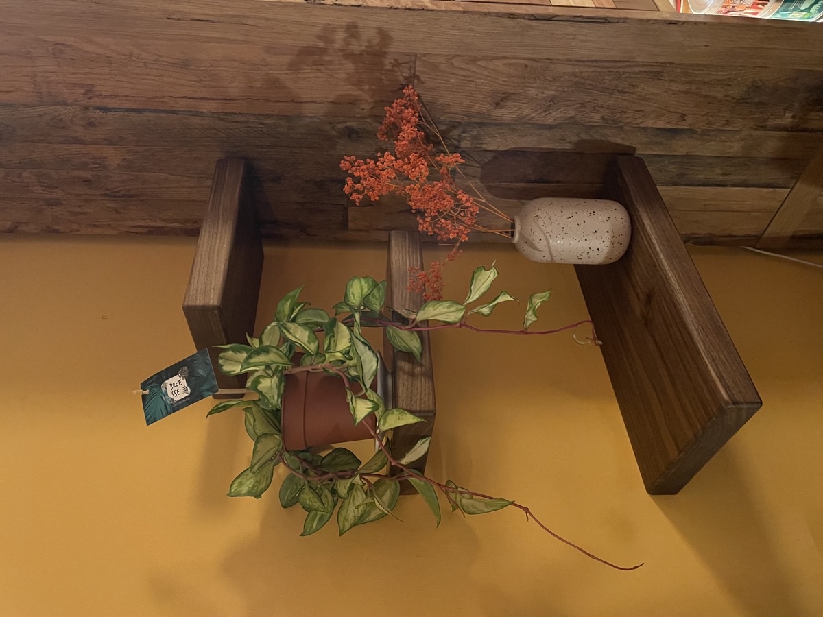 Zwevende notelaar legplanken gemonteerd aan witte muur